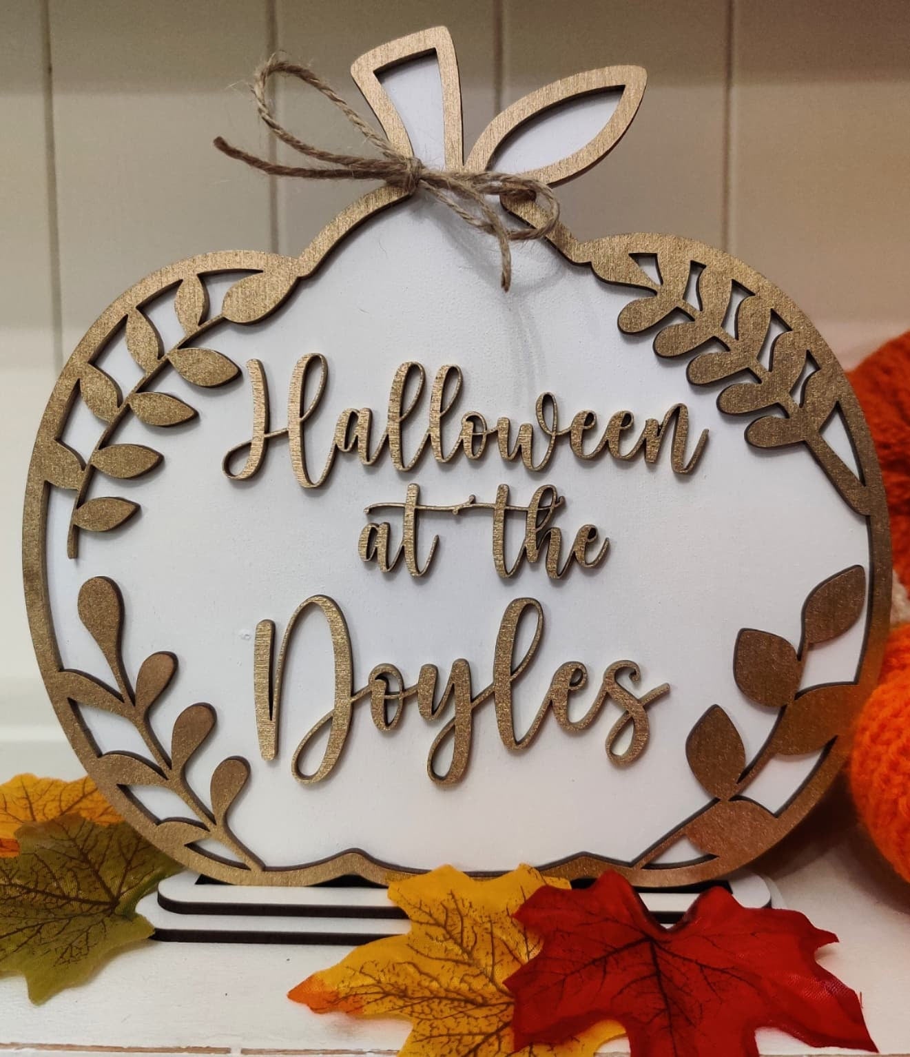 Image of a personalized Halloween family pumpkin plaque. The plaque is made of wood and features a carved pumpkin with the names of the family 